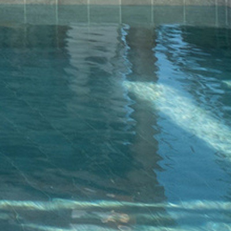 Green-grey tiles under the pool water.
