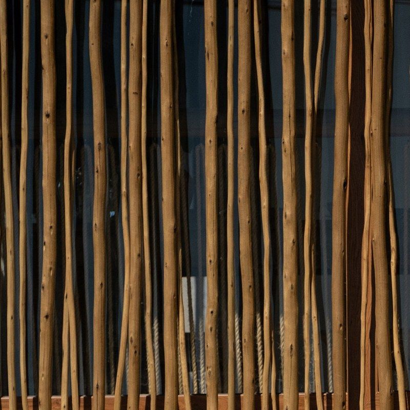 Irregular timber sticks hung side by side.