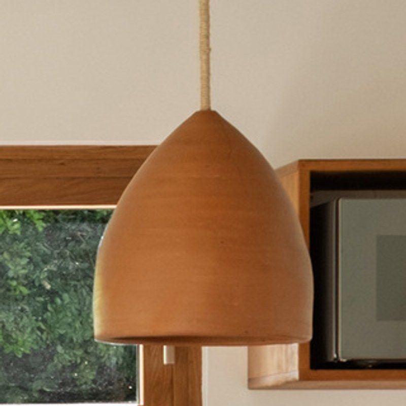 A terracotta pendant lamp hanging on a rope.